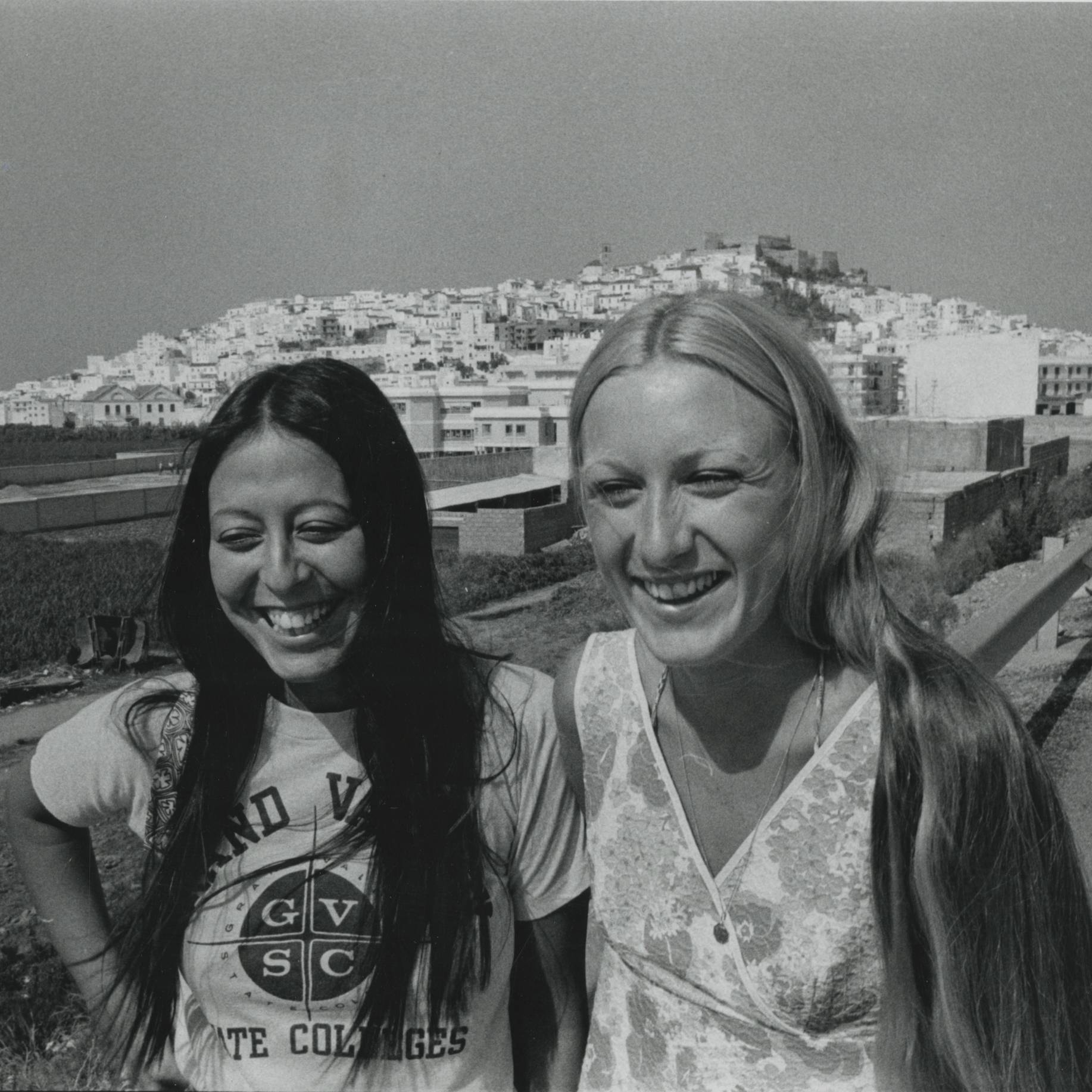black and white photograph of young women in standing in front of cityscape wearing GVSC shirts